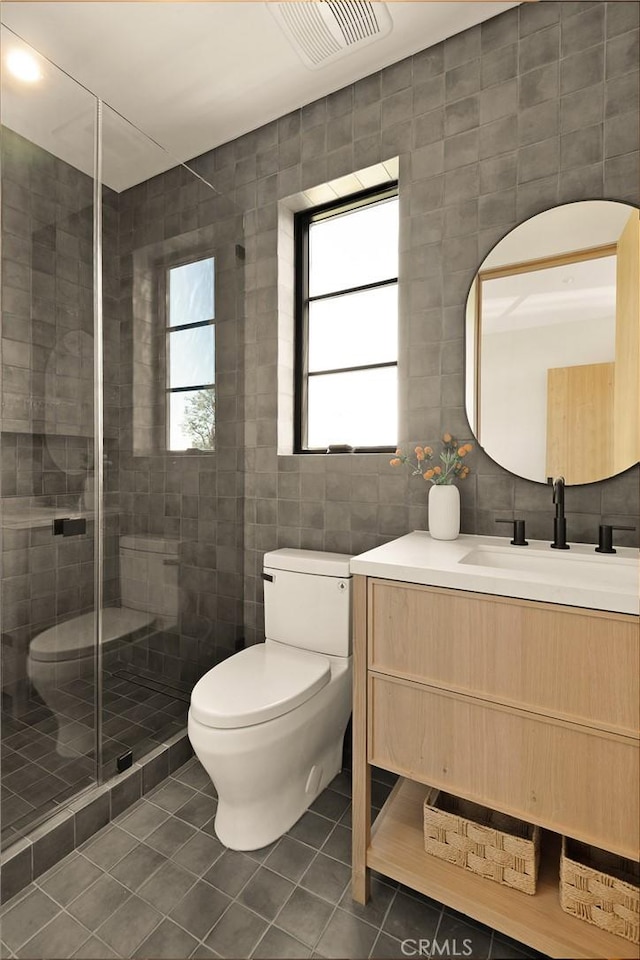 full bath with a healthy amount of sunlight, visible vents, tile walls, tile patterned flooring, and toilet