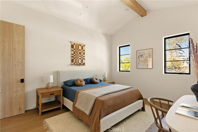 bedroom featuring vaulted ceiling with beams and wood finished floors