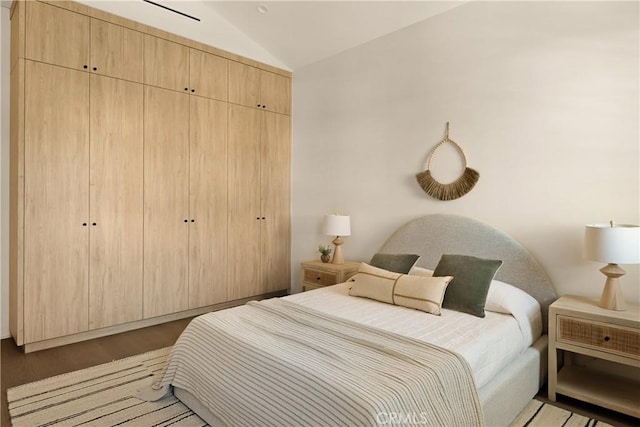 bedroom featuring vaulted ceiling, a closet, and wood finished floors
