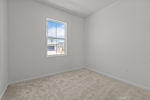 carpeted spare room featuring baseboards