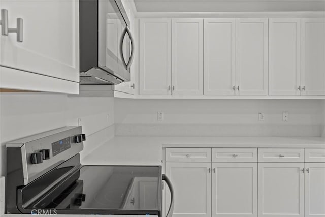 kitchen featuring stainless steel appliances, light countertops, and white cabinets