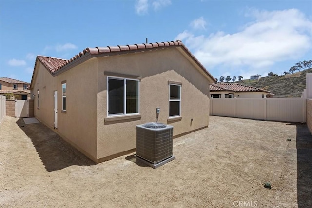 rear view of property featuring a fenced backyard, stucco siding, and cooling unit