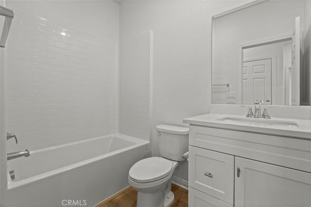 full bath with toilet, wood finished floors, vanity, and shower / washtub combination