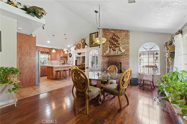 20130 Monte Vista Rd, Apple Valley, CA 92308 - dining space featuring a textured ceiling, light wood finished floors, a fireplace, and lofted ceiling