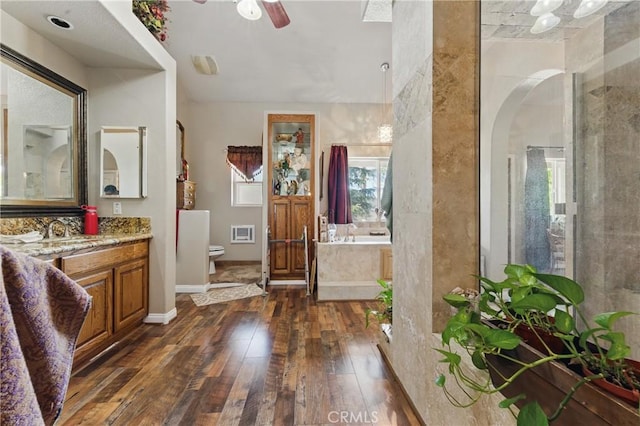 20130 Monte Vista Rd, Apple Valley, CA 92308 - full bathroom with a bath, toilet, ceiling fan, hardwood / wood-style flooring, and vanity