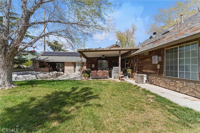 20130 Monte Vista Rd, Apple Valley, CA 92308 - back of property featuring roof mounted solar panels, a yard, a patio area, stone siding, and cooling unit