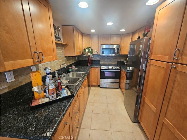 kitchen with light tile patterned floors, brown cabinets, stainless steel appliances, and decorative backsplash