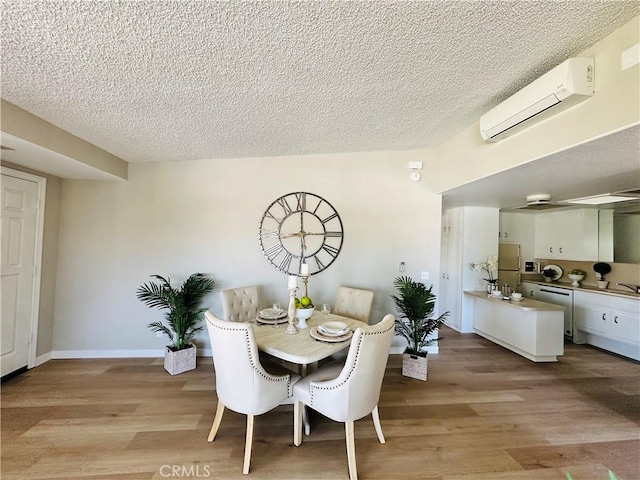 13201 El Dorado Dr Unit M9-207G, Seal Beach, CA 90740 - dining space featuring baseboards, light wood finished floors, a wall mounted AC, and a textured ceiling