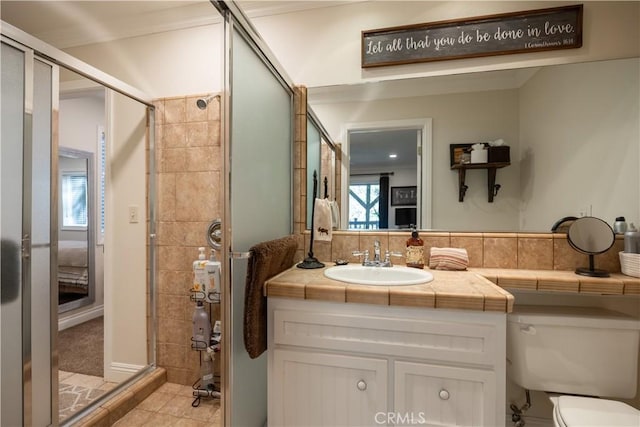 ensuite bathroom featuring vanity, ornamental molding, a stall shower, tile patterned flooring, and ensuite bath