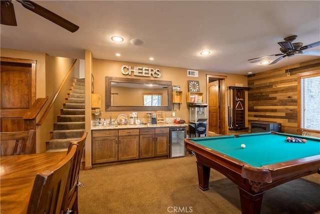 game room with wine cooler, wood walls, ceiling fan, and wet bar
