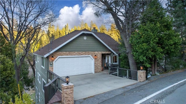 view of front of property with roof with shingles, a gate, a garage, and concrete driveway