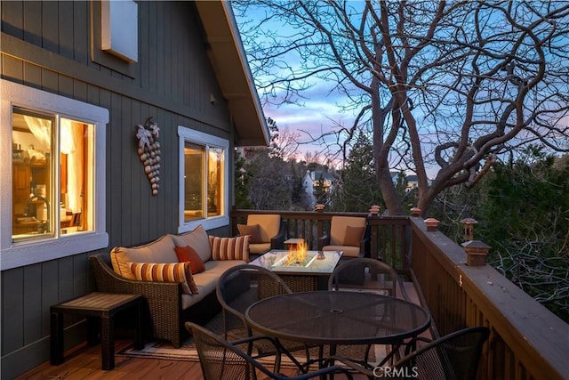 deck at dusk with an outdoor living space with a fire pit and outdoor dining area