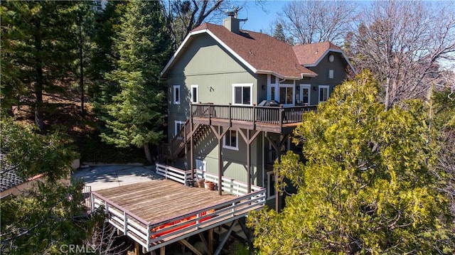 813 Brentwood Dr, Lake Arrowhead, CA 92352 - back of property featuring a deck, a chimney, stairs, a patio area, and roof with shingles