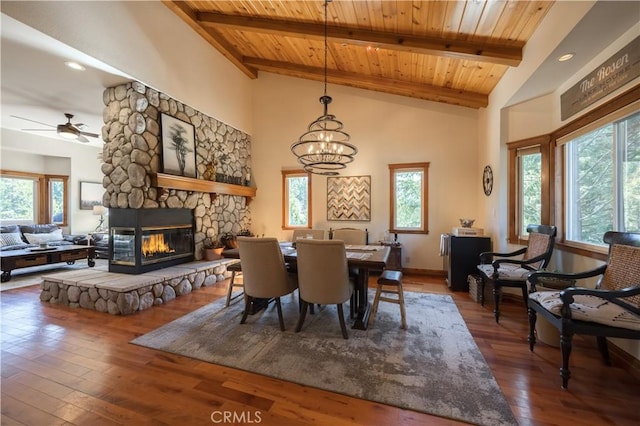 dining room with plenty of natural light, hardwood / wood-style floors, a stone fireplace, and wooden ceiling
