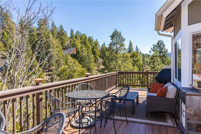 813 Brentwood Dr, Lake Arrowhead, CA 92352 - wooden terrace with outdoor dining area, an outdoor hangout area, and a view of trees