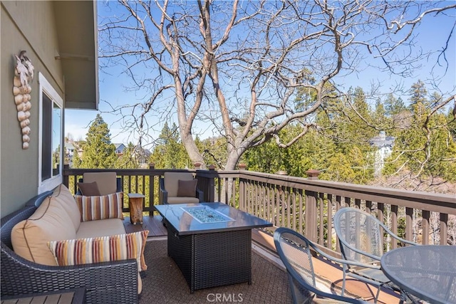 deck with an outdoor living space with a fire pit