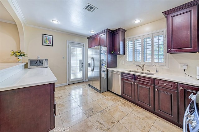 kitchen featuring stainless steel appliances, a sink, crown molding, plenty of natural light, and light countertops