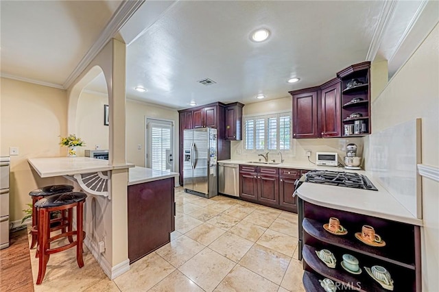 kitchen featuring open shelves, appliances with stainless steel finishes, a peninsula, a sink, and crown molding