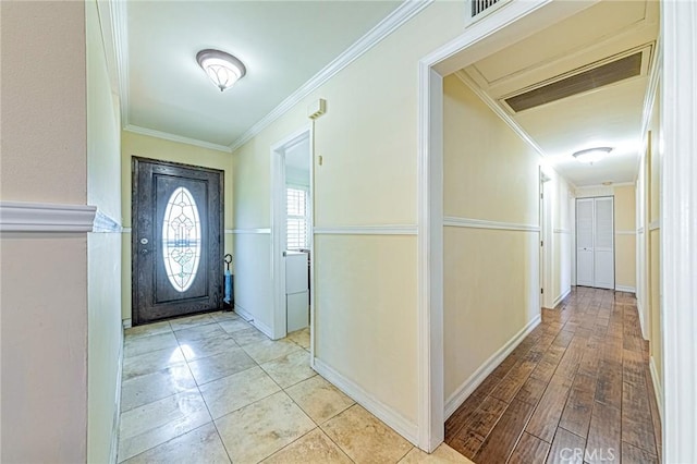 foyer entrance featuring ornamental molding and baseboards