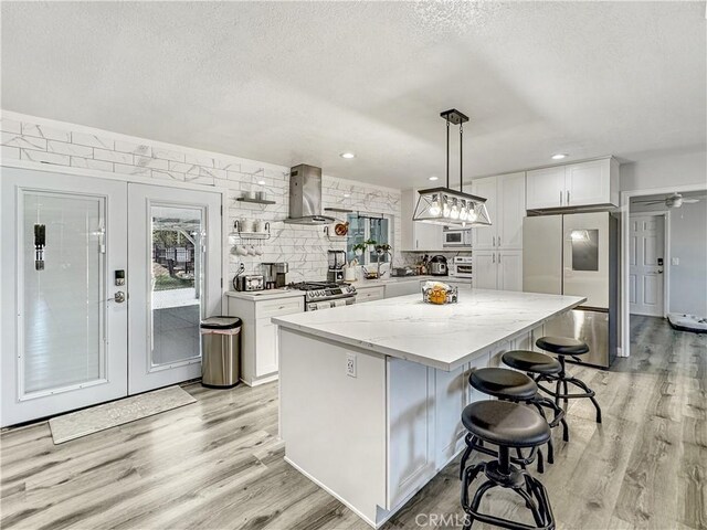 7455 Bangor Ave, Hesperia, CA 92345 - kitchen with wall chimney range hood, a textured ceiling, smart refrigerator, light wood finished floors, and white cabinetry