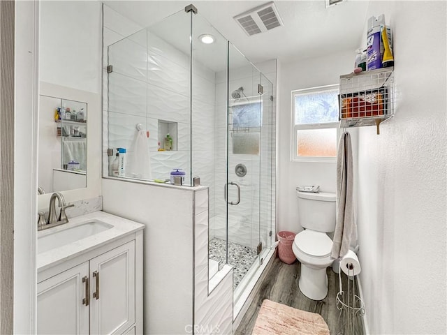 7455 Bangor Ave, Hesperia, CA 92345 - full bathroom featuring visible vents, vanity, wood finished floors, toilet, and a shower stall