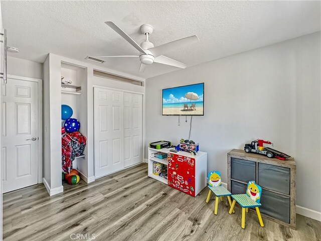 7455 Bangor Ave, Hesperia, CA 92345 - playroom with a textured ceiling, ceiling fan, visible vents, and wood finished floors