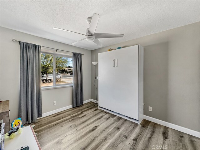 7455 Bangor Ave, Hesperia, CA 92345 - unfurnished bedroom featuring ceiling fan, a textured ceiling, baseboards, a closet, and light wood-style flooring
