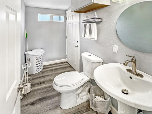 7455 Bangor Ave, Hesperia, CA 92345 - half bathroom with toilet, baseboards, a sink, and wood finished floors