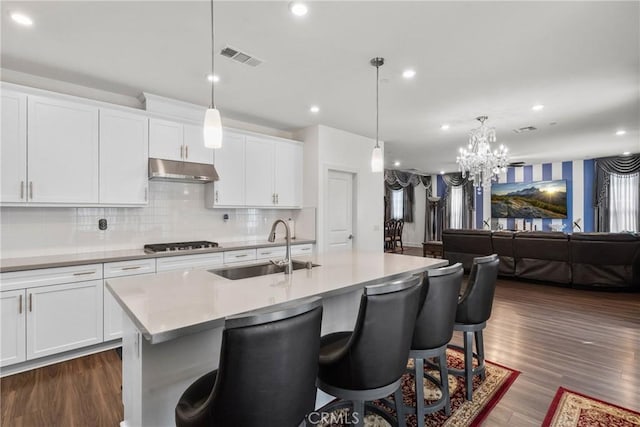 16614 Trailblazer Ave, Chino, CA 91708 - kitchen with visible vents, a sink, gas stovetop, a kitchen bar, and under cabinet range hood