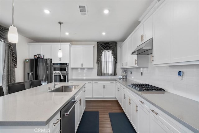 16614 Trailblazer Ave, Chino, CA 91708 - kitchen with white cabinets, under cabinet range hood, a center island with sink, stainless steel appliances, and a sink