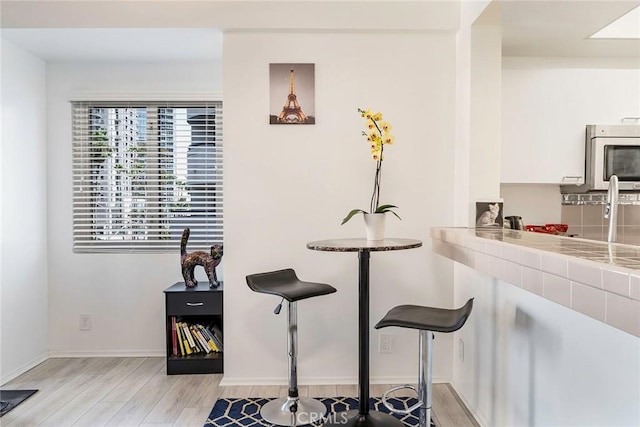 dining room featuring light wood-style flooring and baseboards