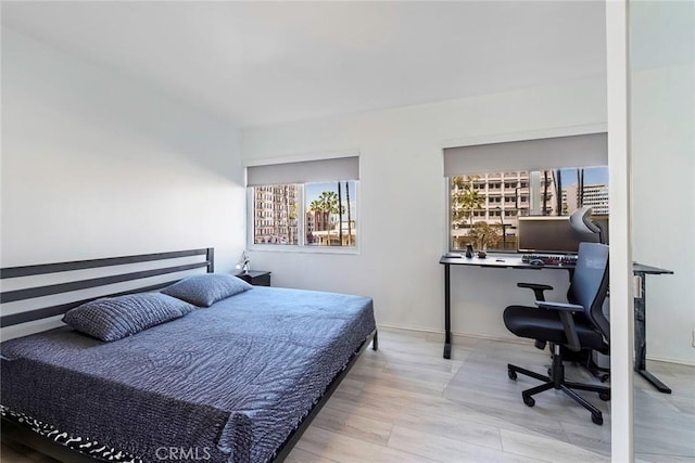 bedroom with baseboards and wood finished floors