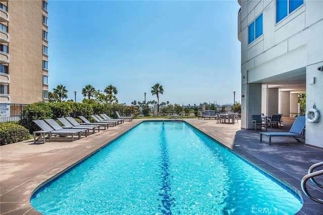 community pool featuring fence and a patio