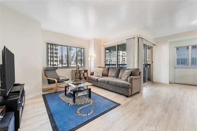 living area with light wood-style flooring and baseboards