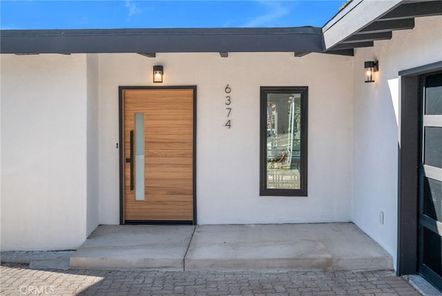 entrance to property with stucco siding