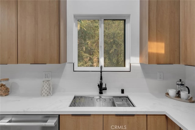 kitchen featuring dishwasher, modern cabinets, a sink, light stone countertops, and decorative backsplash