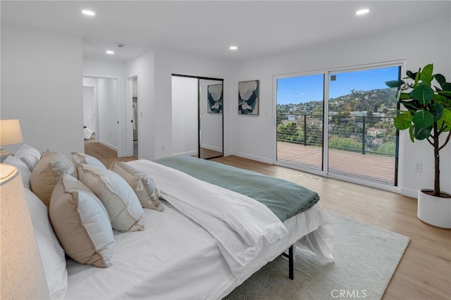 bedroom with visible vents, baseboards, recessed lighting, wood finished floors, and access to exterior