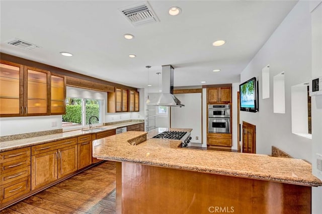 25 Bennington, Irvine, CA 92620 - kitchen with visible vents, brown cabinetry, range hood, and appliances with stainless steel finishes