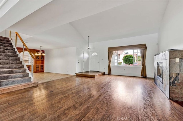 25 Bennington, Irvine, CA 92620 - unfurnished living room with a tiled fireplace, wood-type flooring, high vaulted ceiling, and stairway