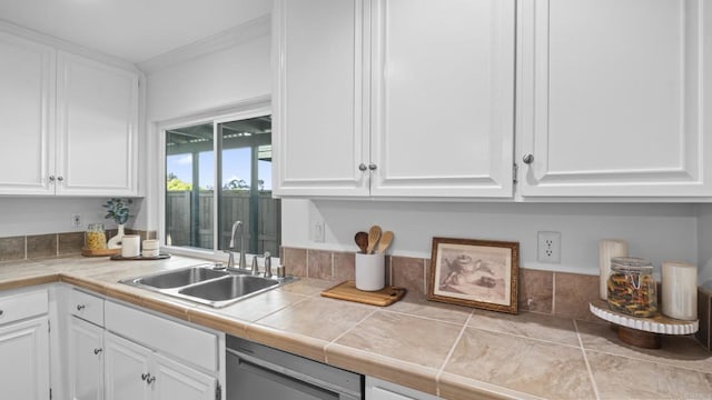 kitchen featuring stainless steel dishwasher, white cabinetry, and a sink
