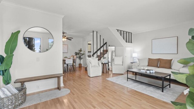 living room featuring ornamental molding, wood finished floors, and stairway