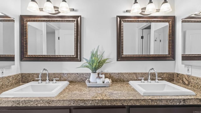 full bathroom with a sink and double vanity