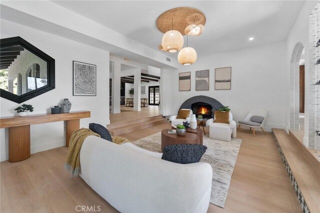 115 Buckskin Rd, Bell Canyon, CA 91307 - living area with a warm lit fireplace, wood finished floors, baseboards, arched walkways, and recessed lighting