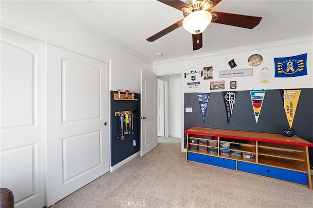 rec room featuring crown molding, carpet flooring, and a ceiling fan