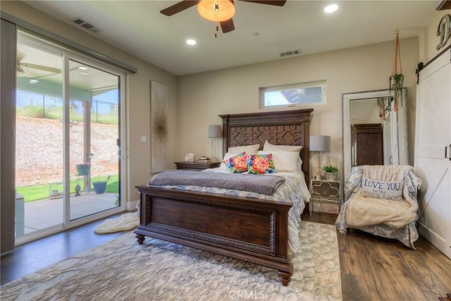 bedroom with visible vents, wood finished floors, and multiple windows