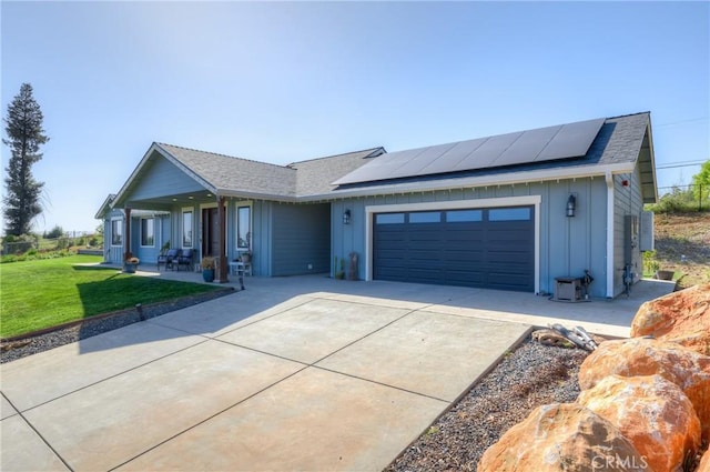 view of front of home with board and batten siding, an attached garage, driveway, and a front lawn