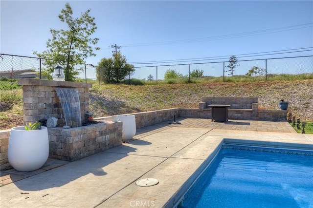 pool with a patio and fence
