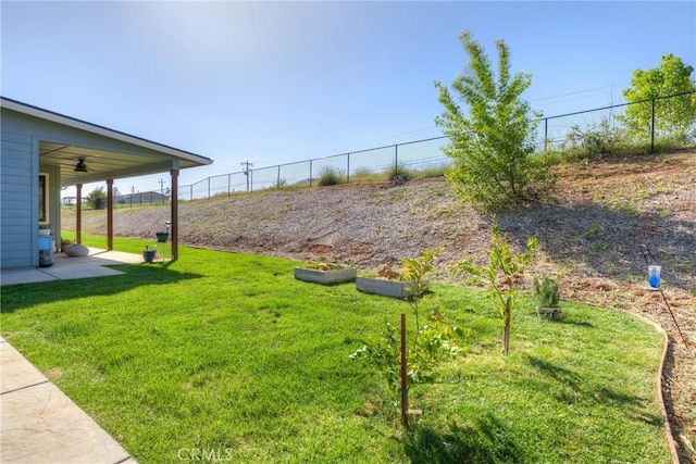 view of yard featuring fence and ceiling fan