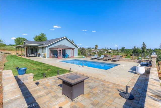 pool featuring a patio, a yard, and a fire pit