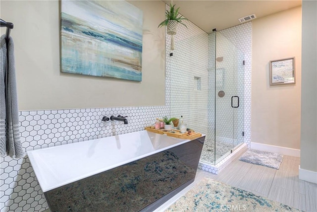 full bath featuring visible vents, tile walls, a stall shower, tile patterned floors, and a soaking tub